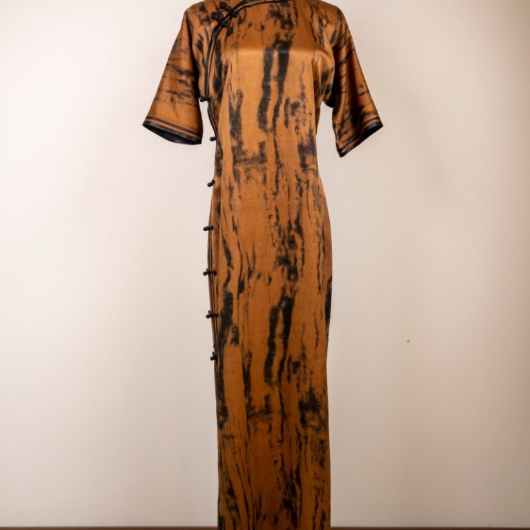 The drape of the silk cheongsam’s hemline and its overall appearance are well-matched.